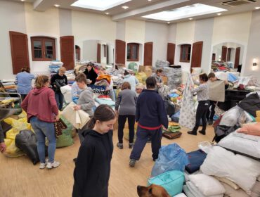 Wolontariusze sortujący dary w magazynie w Komborni